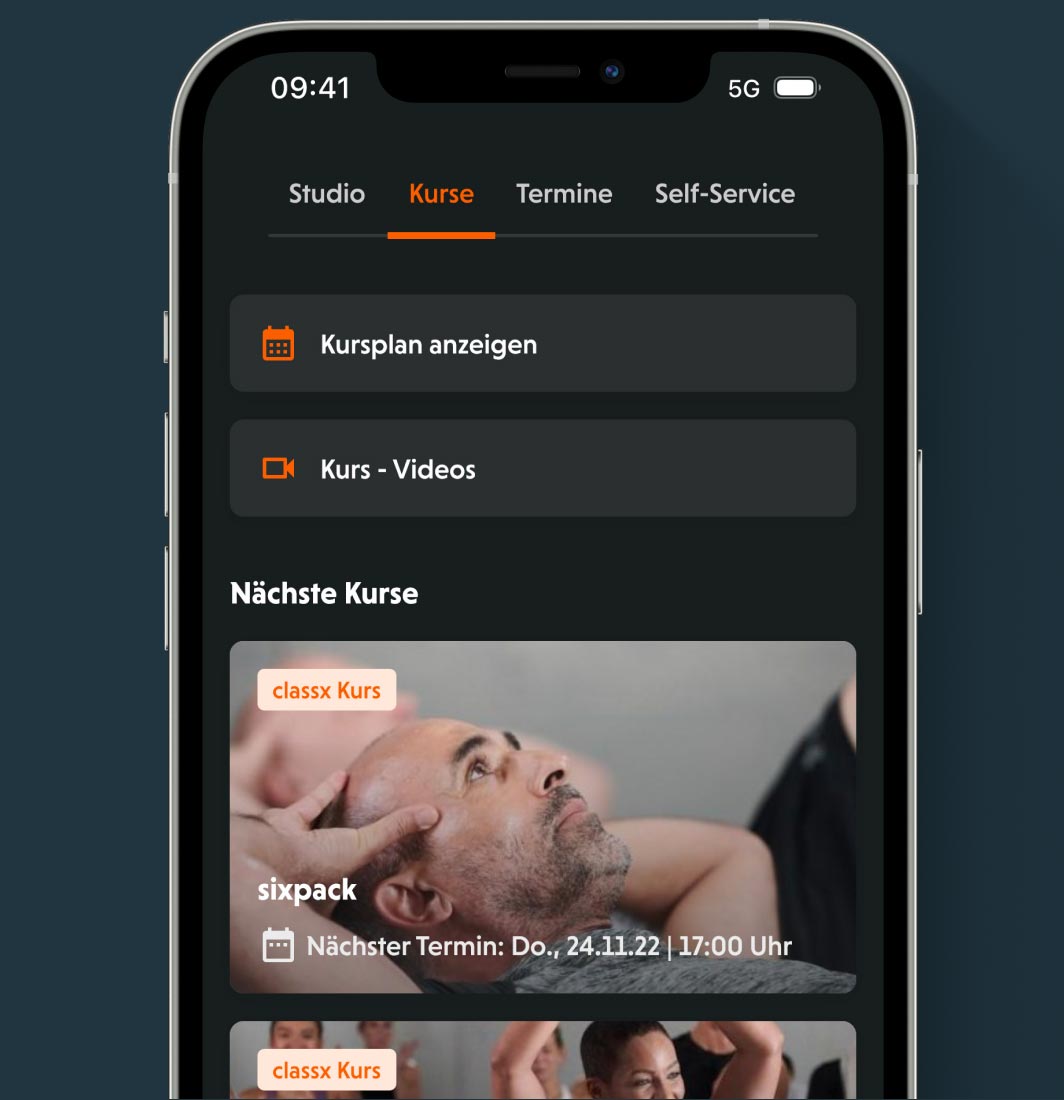 Bild: Ein Smartphone mit dem geöffneten Reiter „Kurse“. Zu sehen sind Optionen wie „Kursplan anzeigen“ und „Kurs – Videos“. Darunter folgen anstehende Kurse mit Titel, Bild und Uhrzeit.